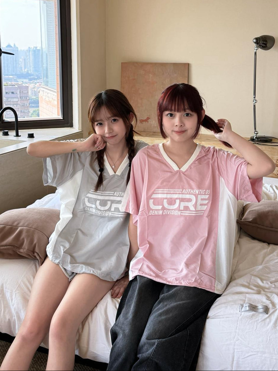 Two people sitting on a bed in a room with a cityscape view.